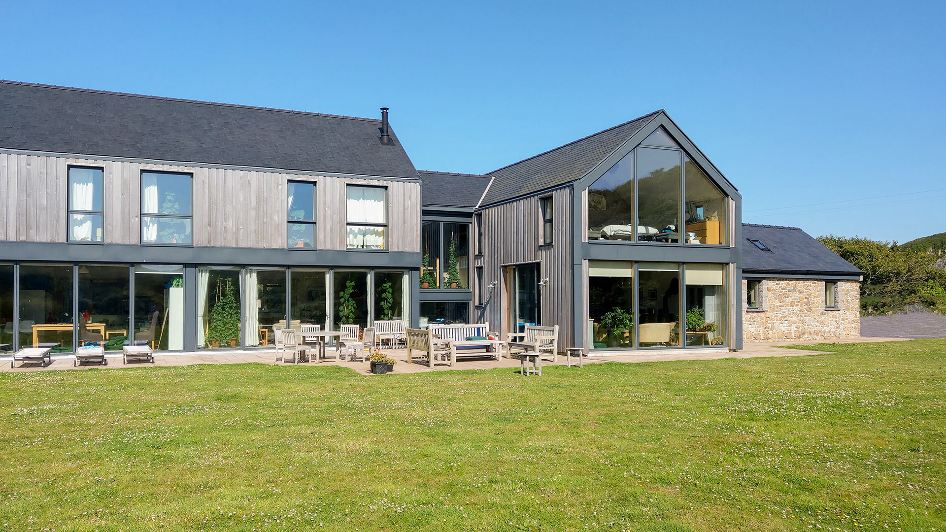 front view of contemporary timer clad house with garden