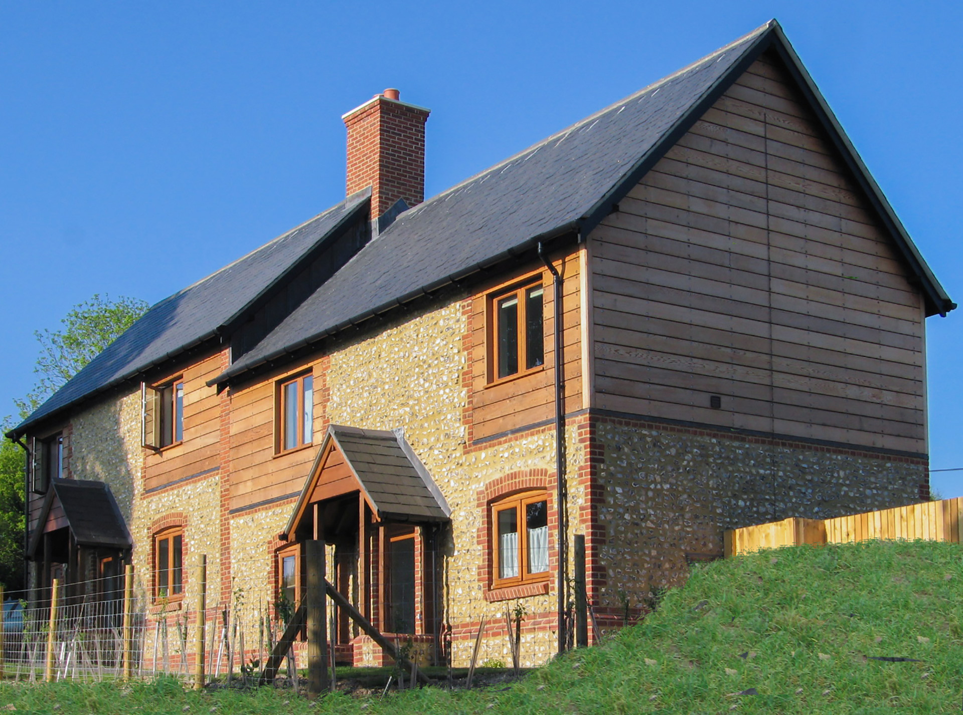 street view of two houses with stone walls and timber cladding