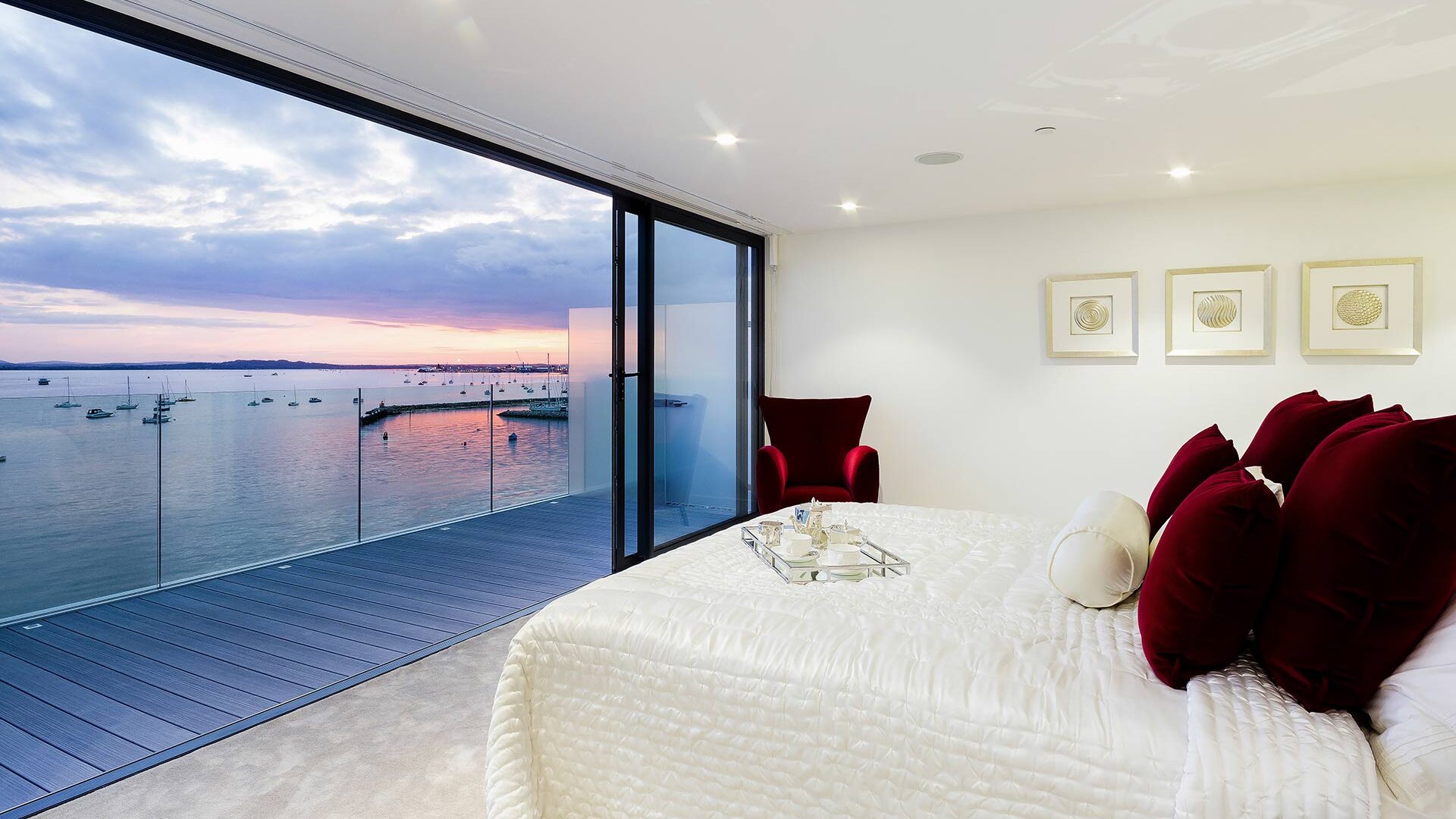 interior bedroom with balcony and beautiful sea views at sunset