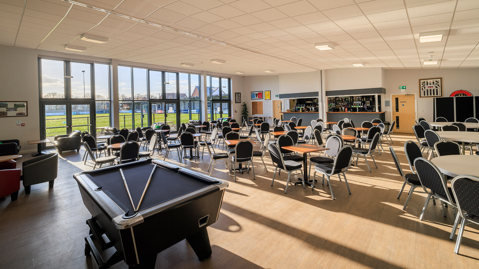 wimborne town football club interior hospitality area with tables and chairs and a bar area