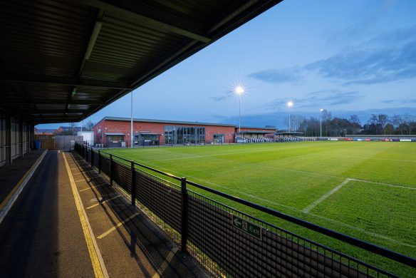 wimborne football club pitch and clubhouse at night with lights on