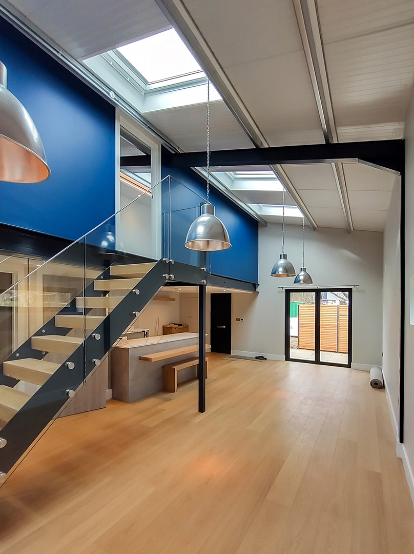 open plan kitchen with staircase to first floor with blue wall