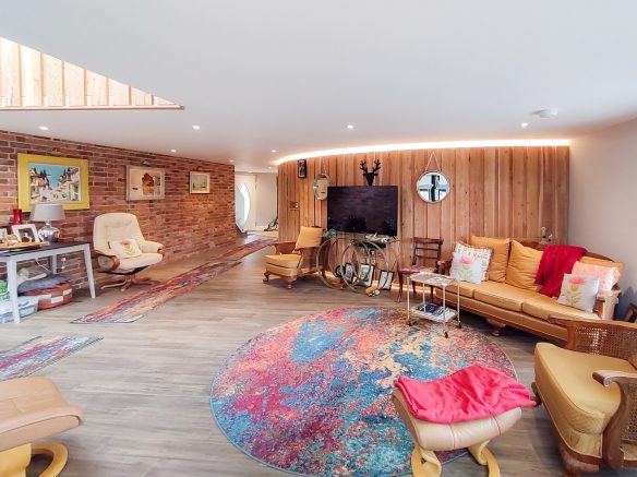 open plan living space with curved wood cladded wall