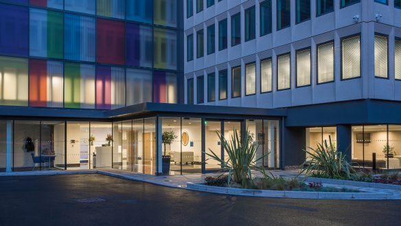 entrance to reception area of office building at dusk with lights on