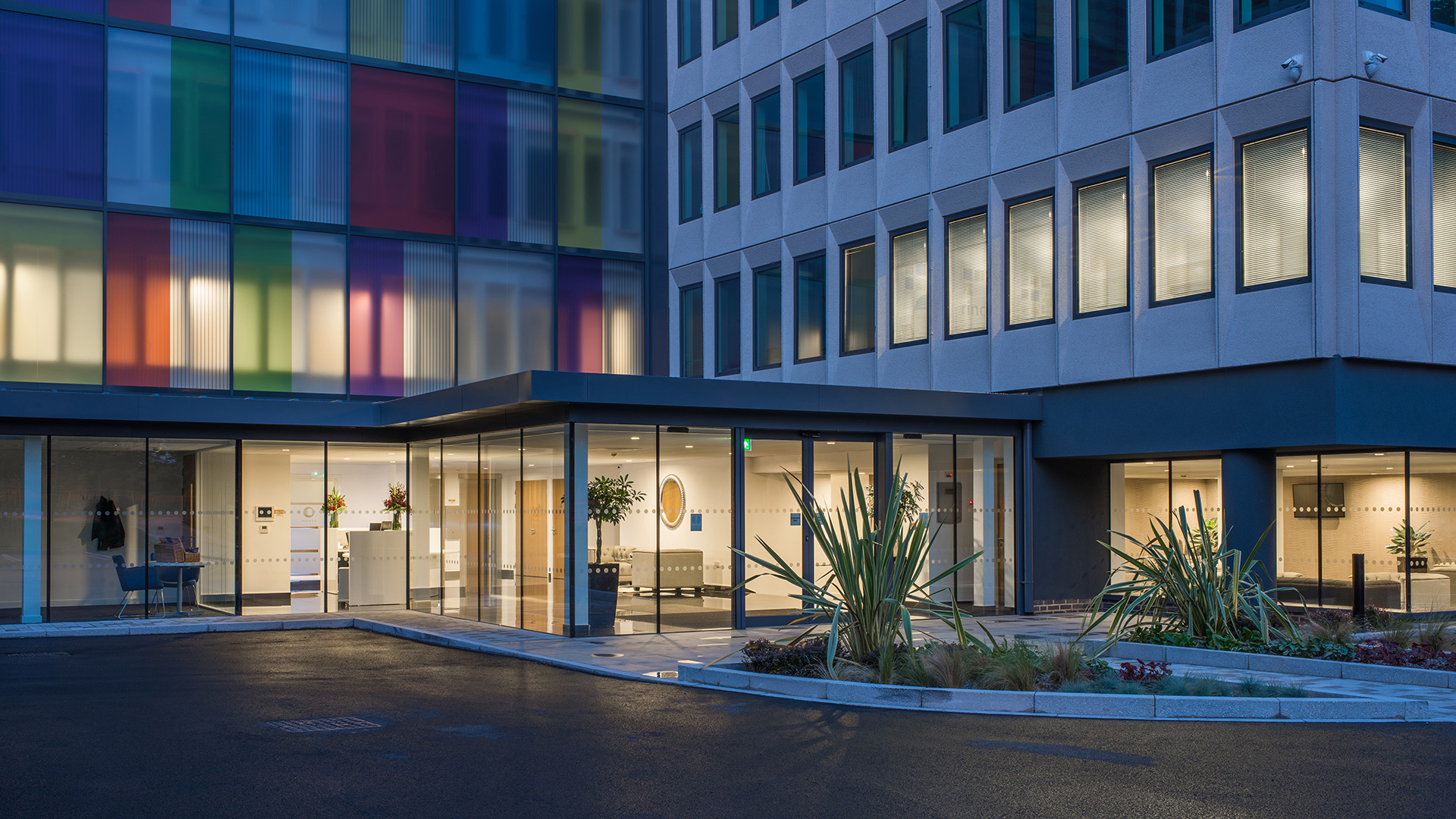 entrance to reception area of office building at dusk with lights on