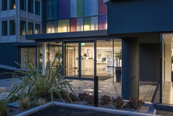 entrance to reception area of office building at dusk with lights on