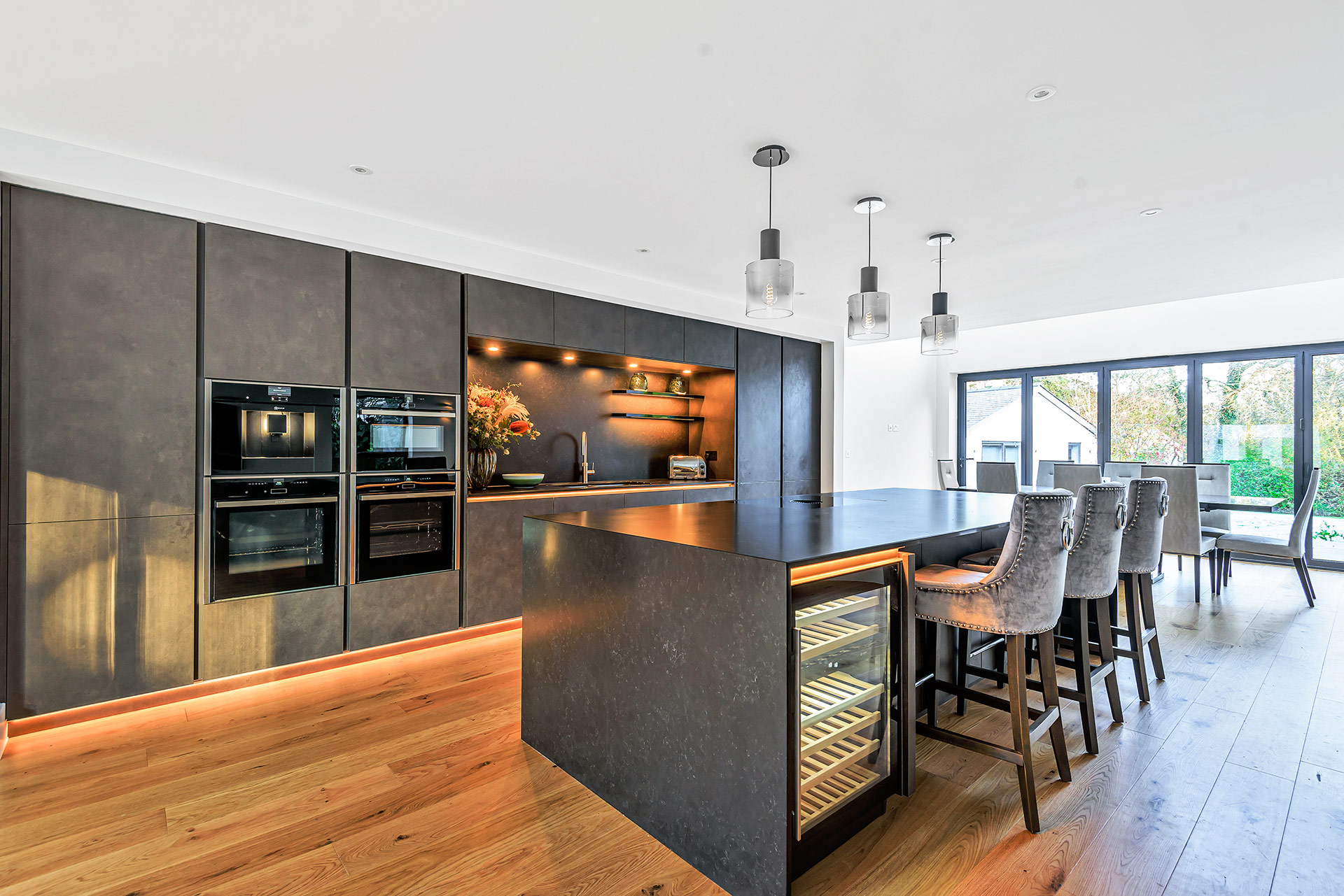 modern internal kitchen dining area with feature lighting on cupboards and kitchen islands