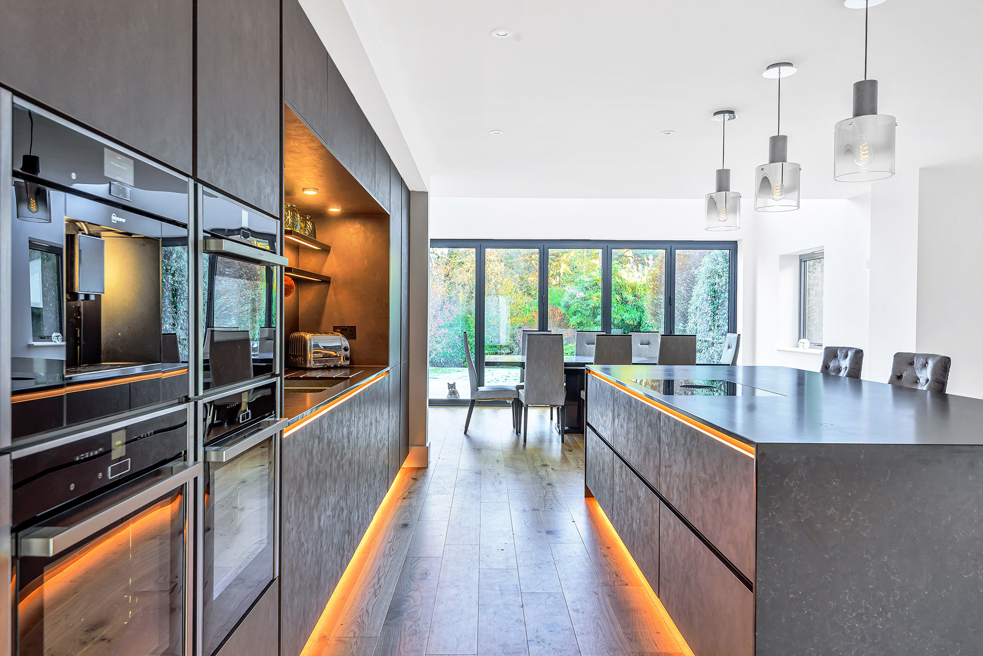 modern internal kitchen with feature lighting on cupboards and kitchen islands bringing warm tones