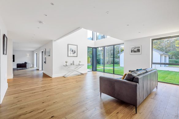 open plan living space with double height areas and large windows looking to garden