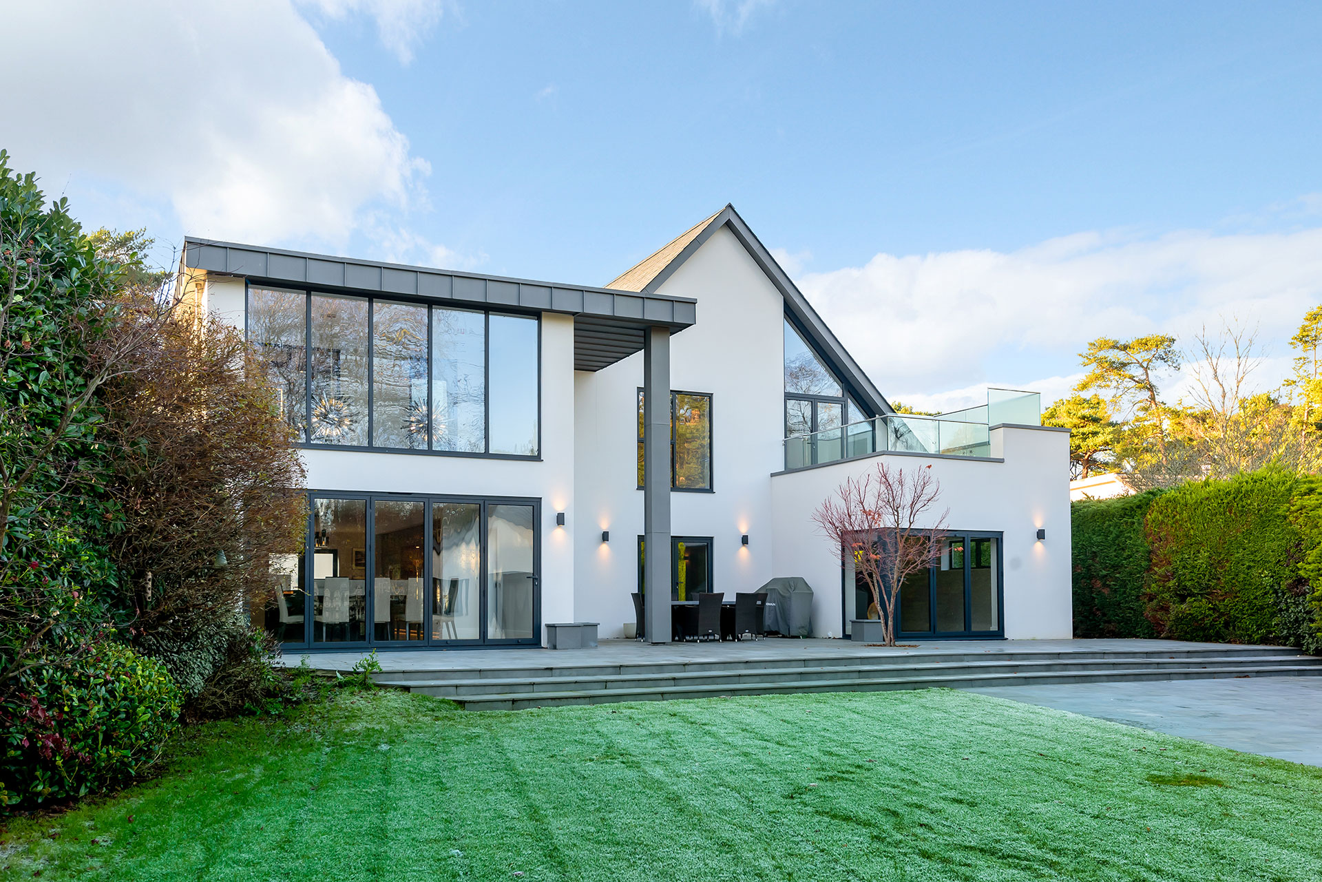 rear view of contemporary white house with zinc cladding and outhouse