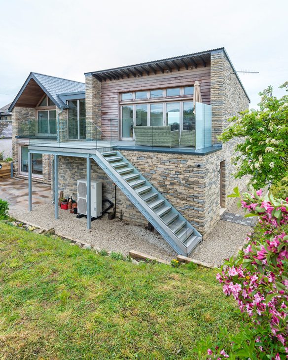 rear view of house with external staircase leading to first floor balcony patio