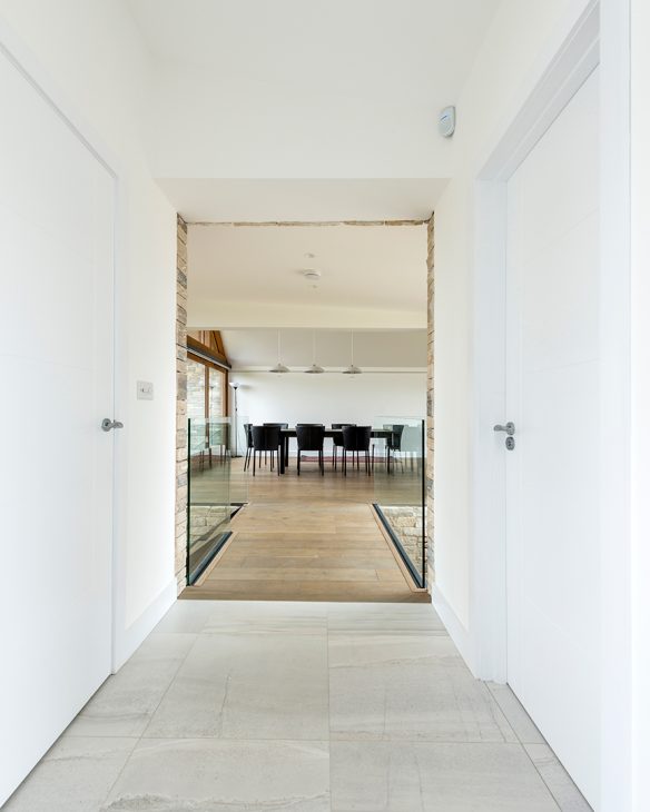 modern bright walkway leading to large open plan dining kitchen room