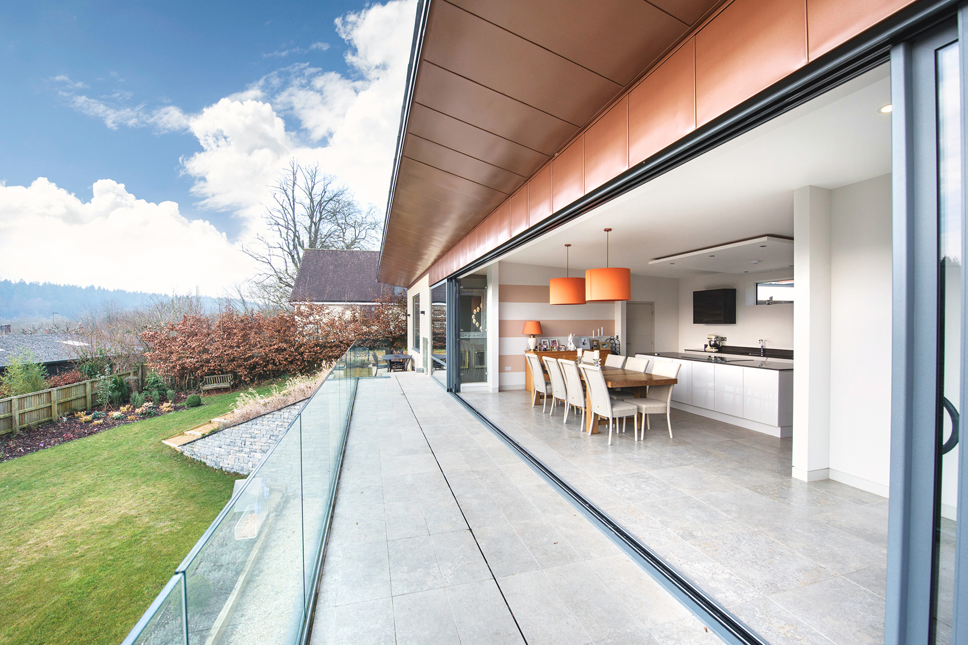 balcony view of house and garden with large sliding doors and copper cladding