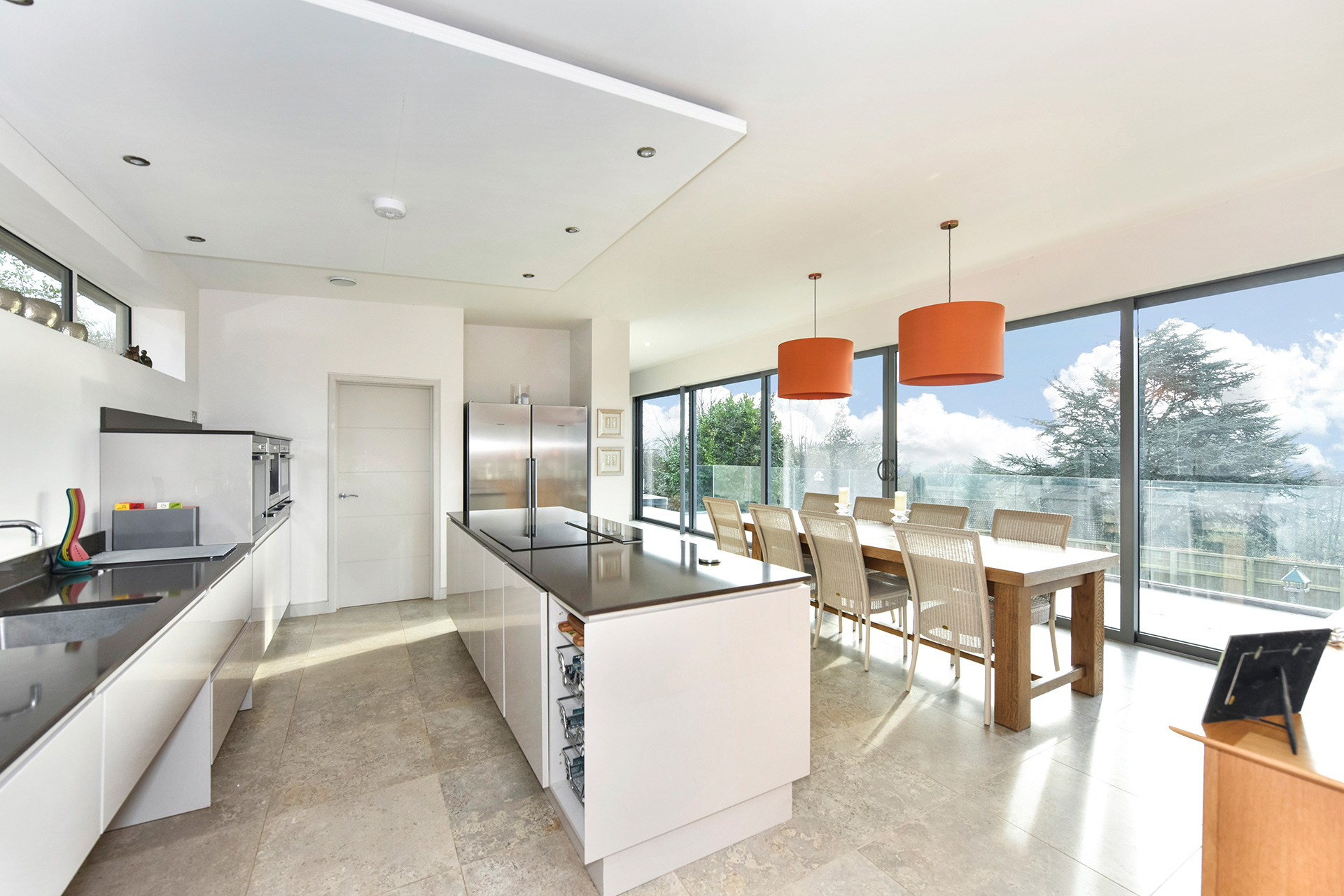 open plan modern kitchen and dining area with sliding doors leading to balcony