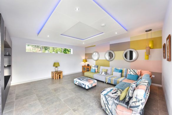 modern living area with colourful sofa and high level windows