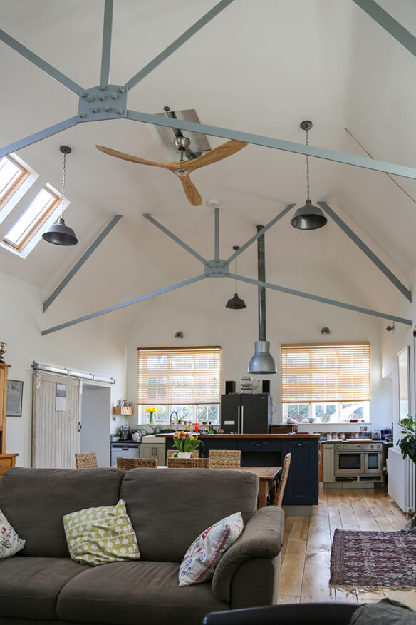 exposed metal truss in open plan double height kitchen and living area