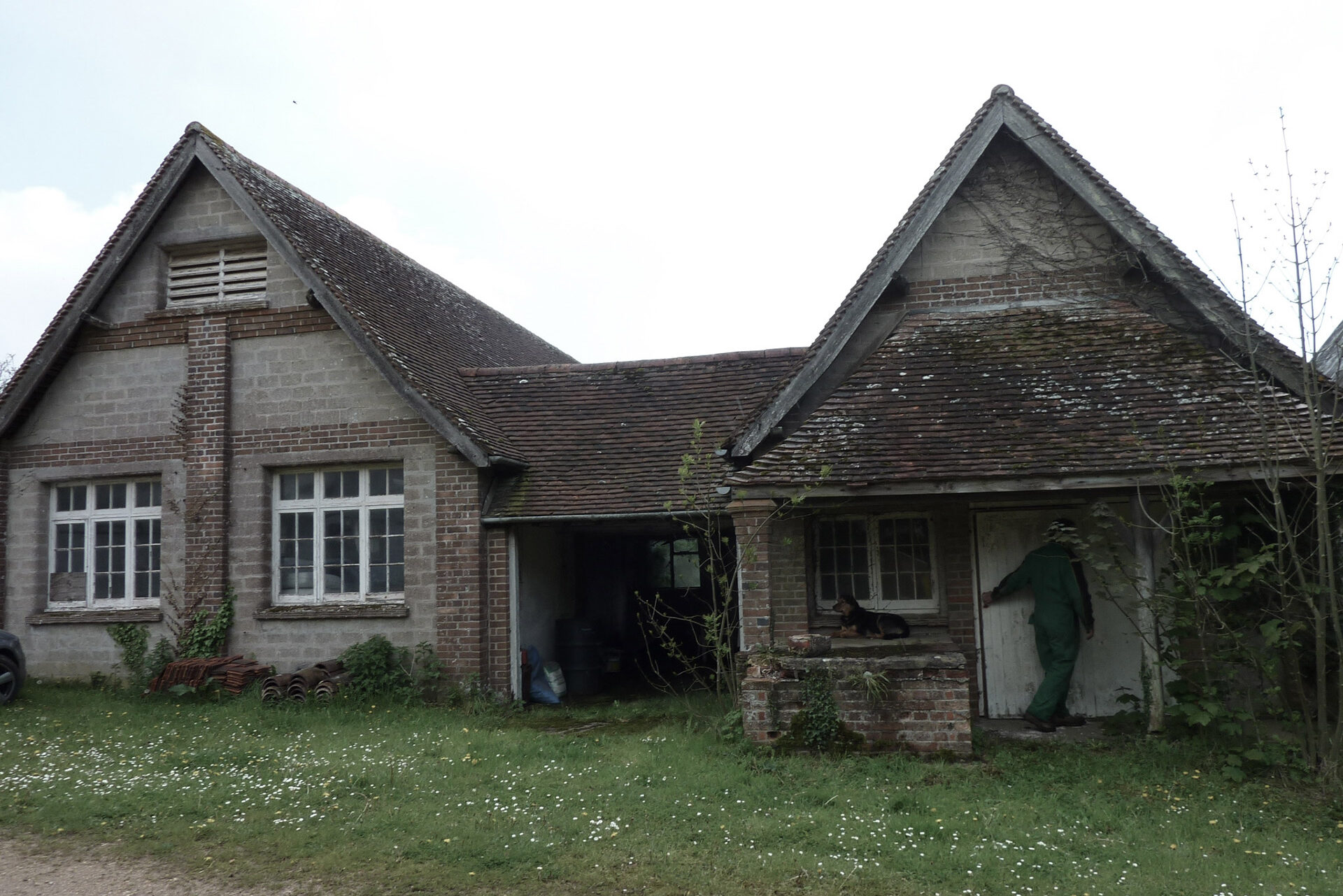 before photo of front of house with stone walls and red tiles roof