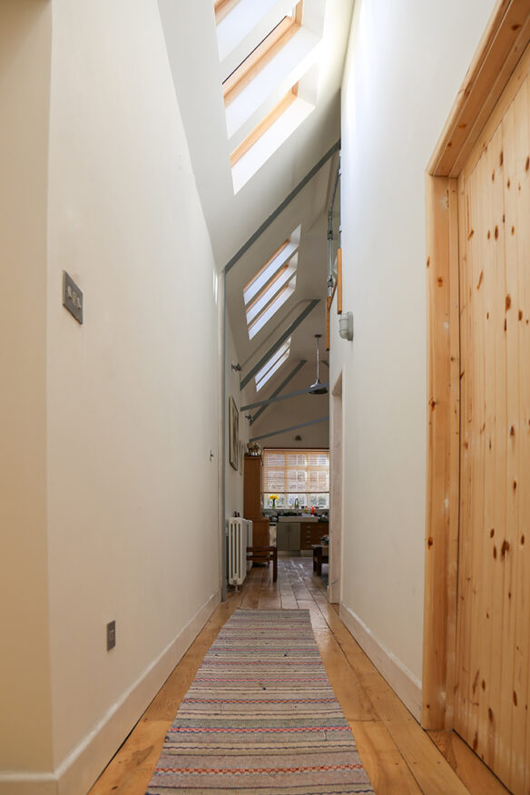 interior hallway with roof lights and double height spacing leading to open plan living and kitchen area