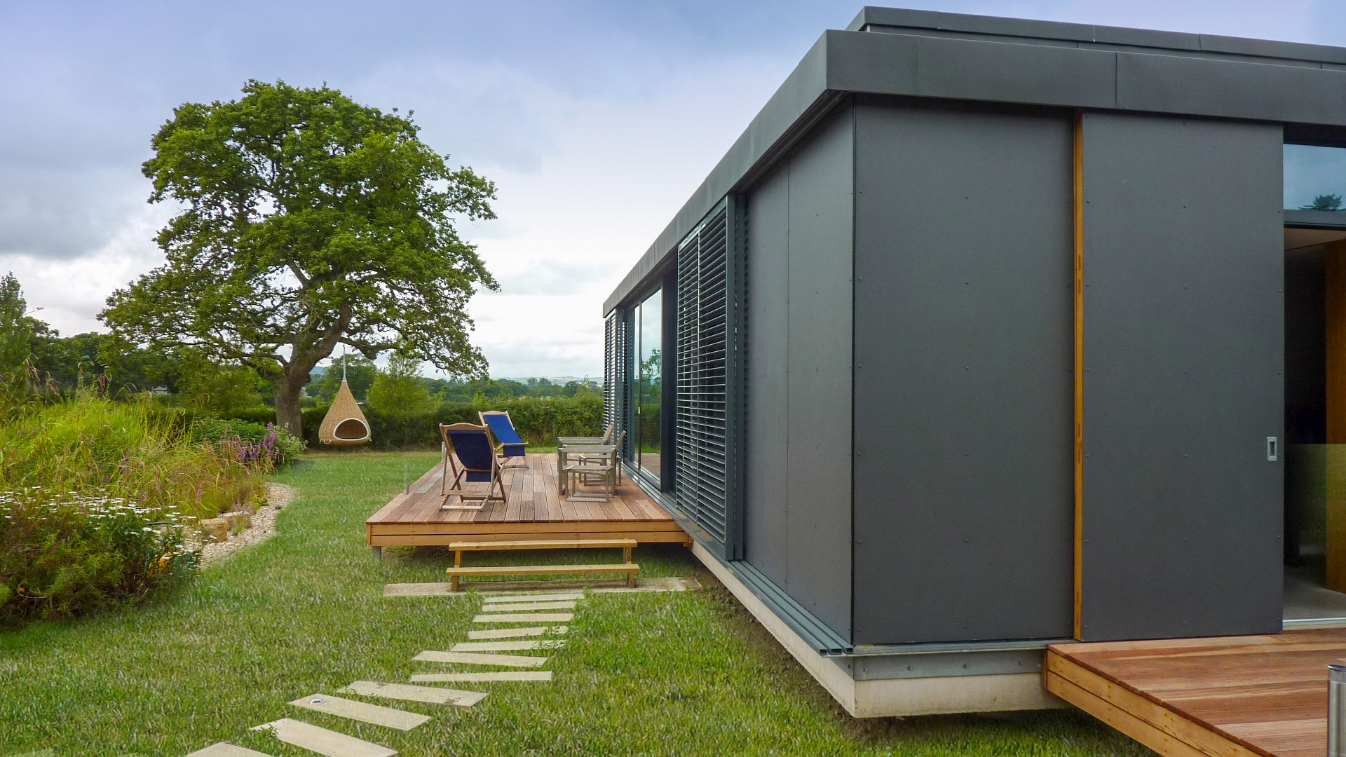 decking area outside single storey house with zinc cladding