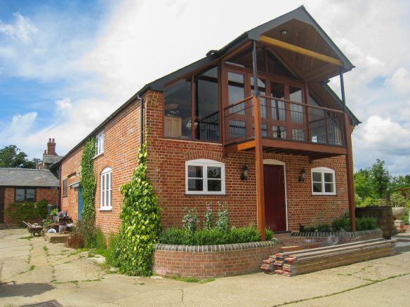 balcony above entrance to red brick house