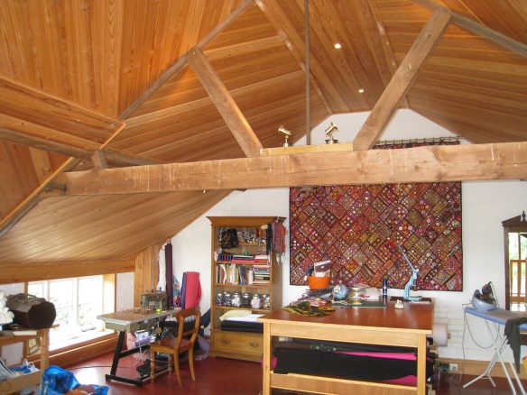 interior sewing room with exposed wooden beam and tapestry on wall