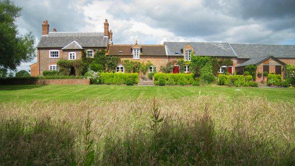 large converted farmhouse with various roof heights taken from garden