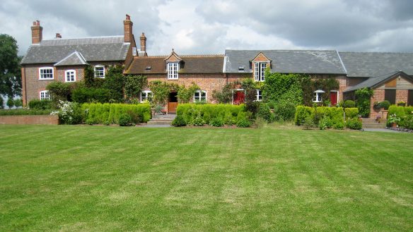 large converted farmhouse with various roof heights taken from garden