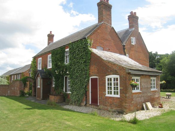 gable end of red brick house with ivy growing on wall