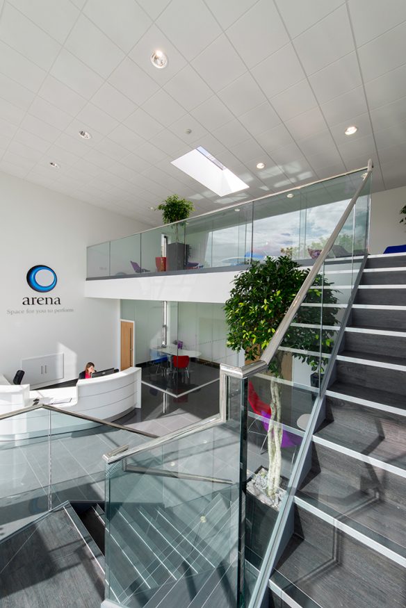 interior reception area with dog legged staircase and glass balustrade