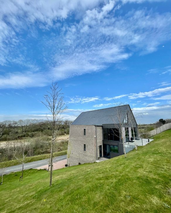 new house with pitched roof and stone wall