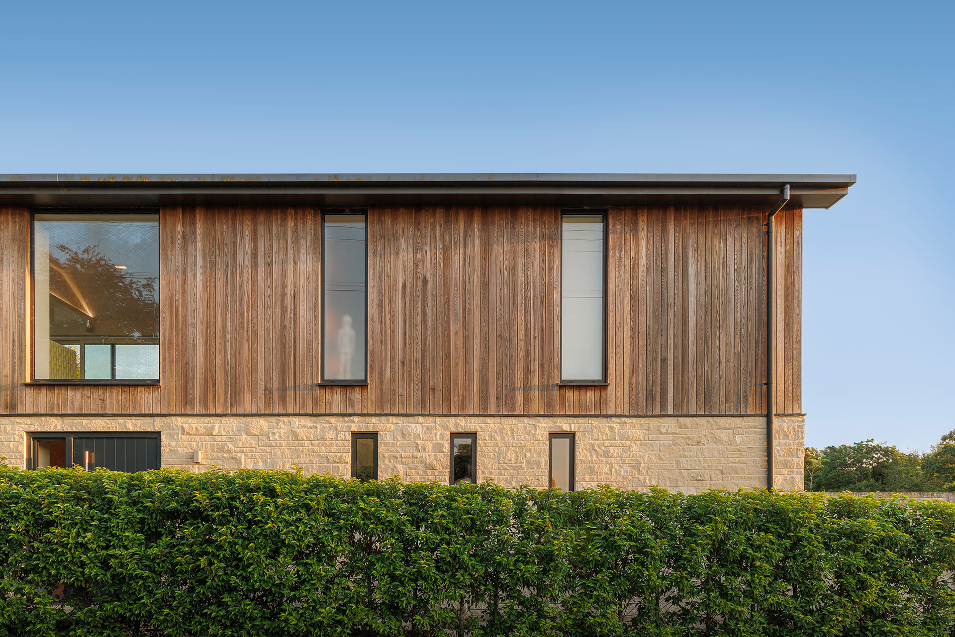 detail view of house with timber cladding and stone on ground floor