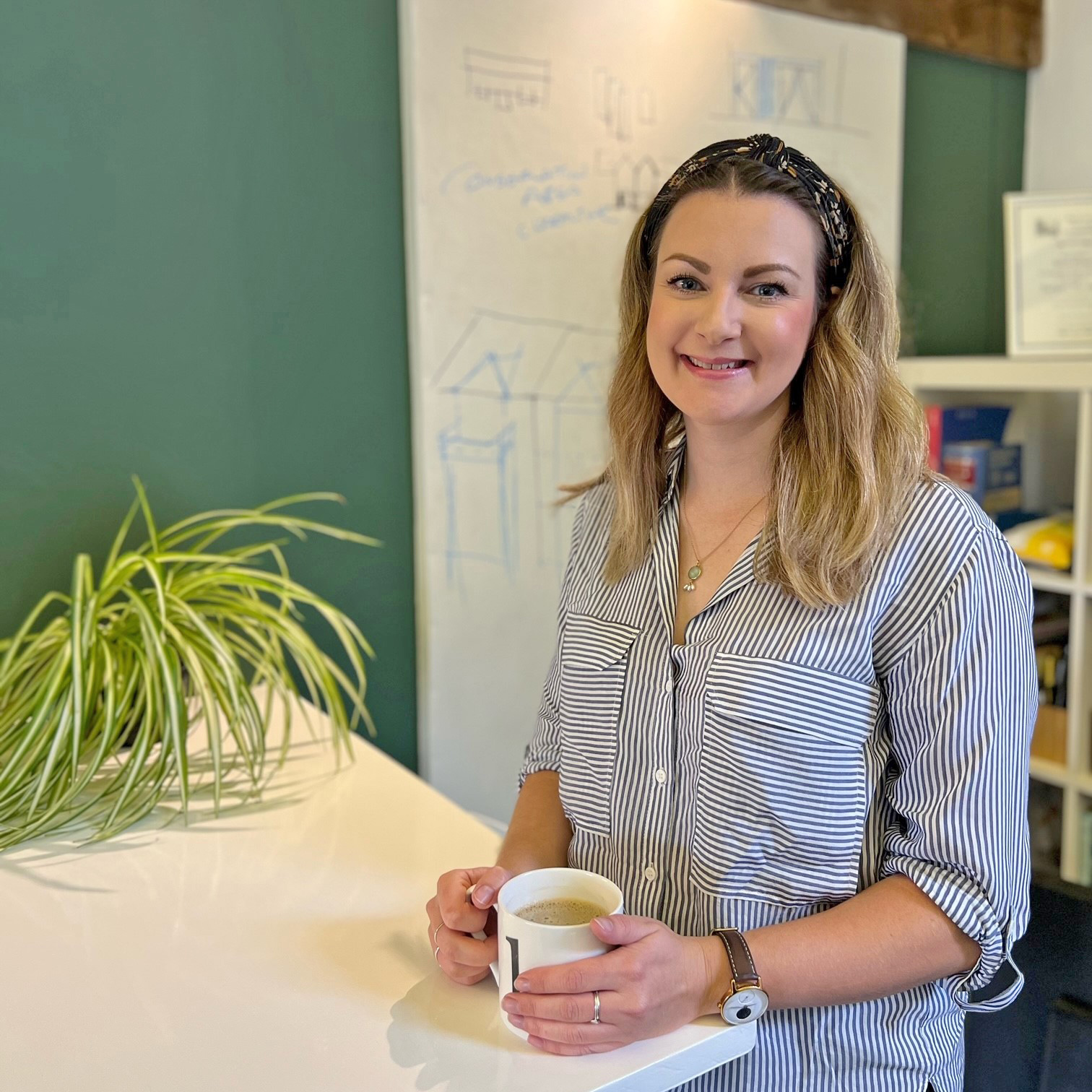 woman smiling holding coffee mug resting on table