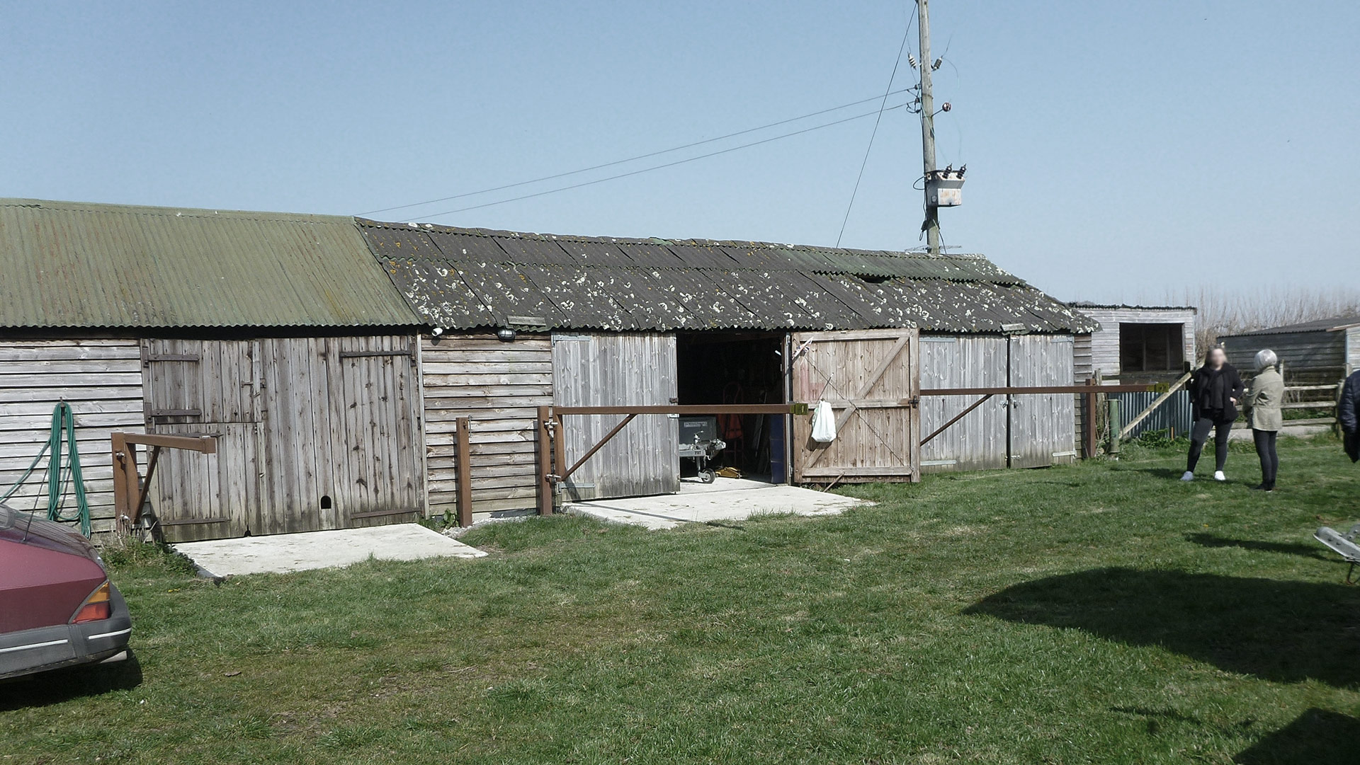 before photo of agricultural barns with corrugated roofs