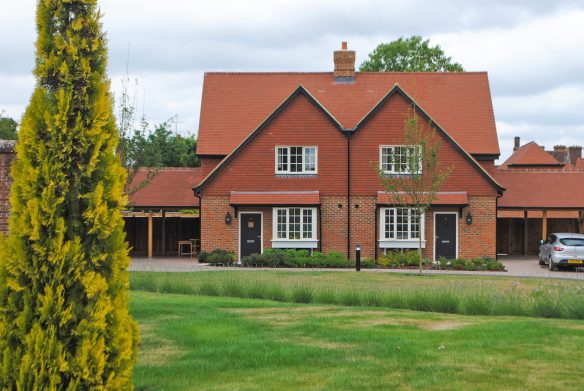 pair of new houses in traditional red brick style with grass in front