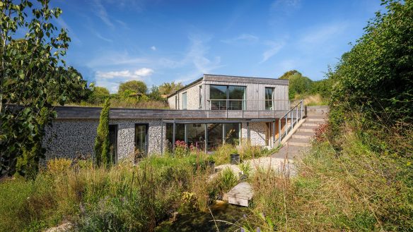 garden view of hidden house with stone walls and external steps up to first floor