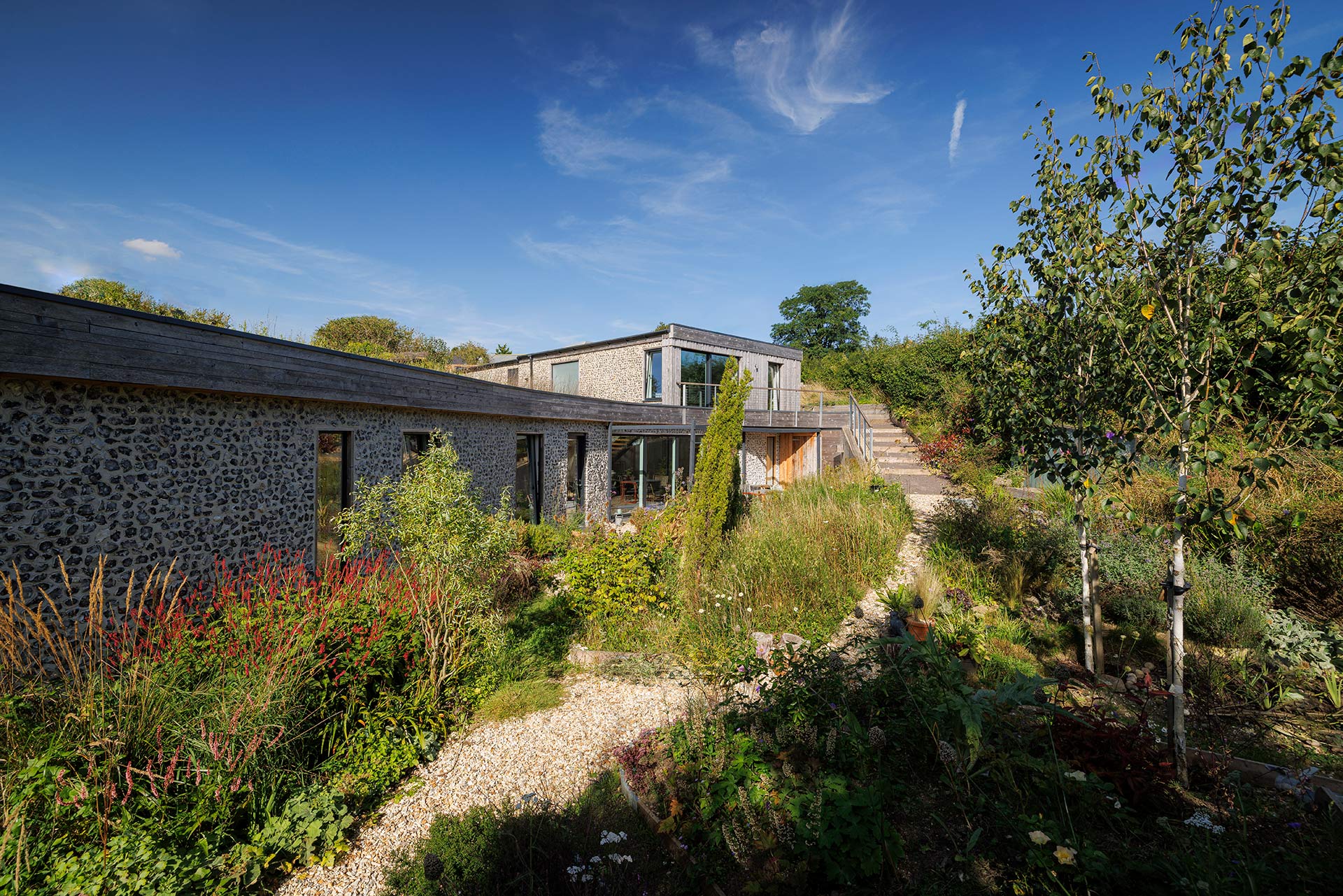 external garden and rear view of house with stone walls and external stairs in garden