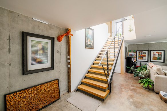 open tread staircase in open plan living space with concrete walls