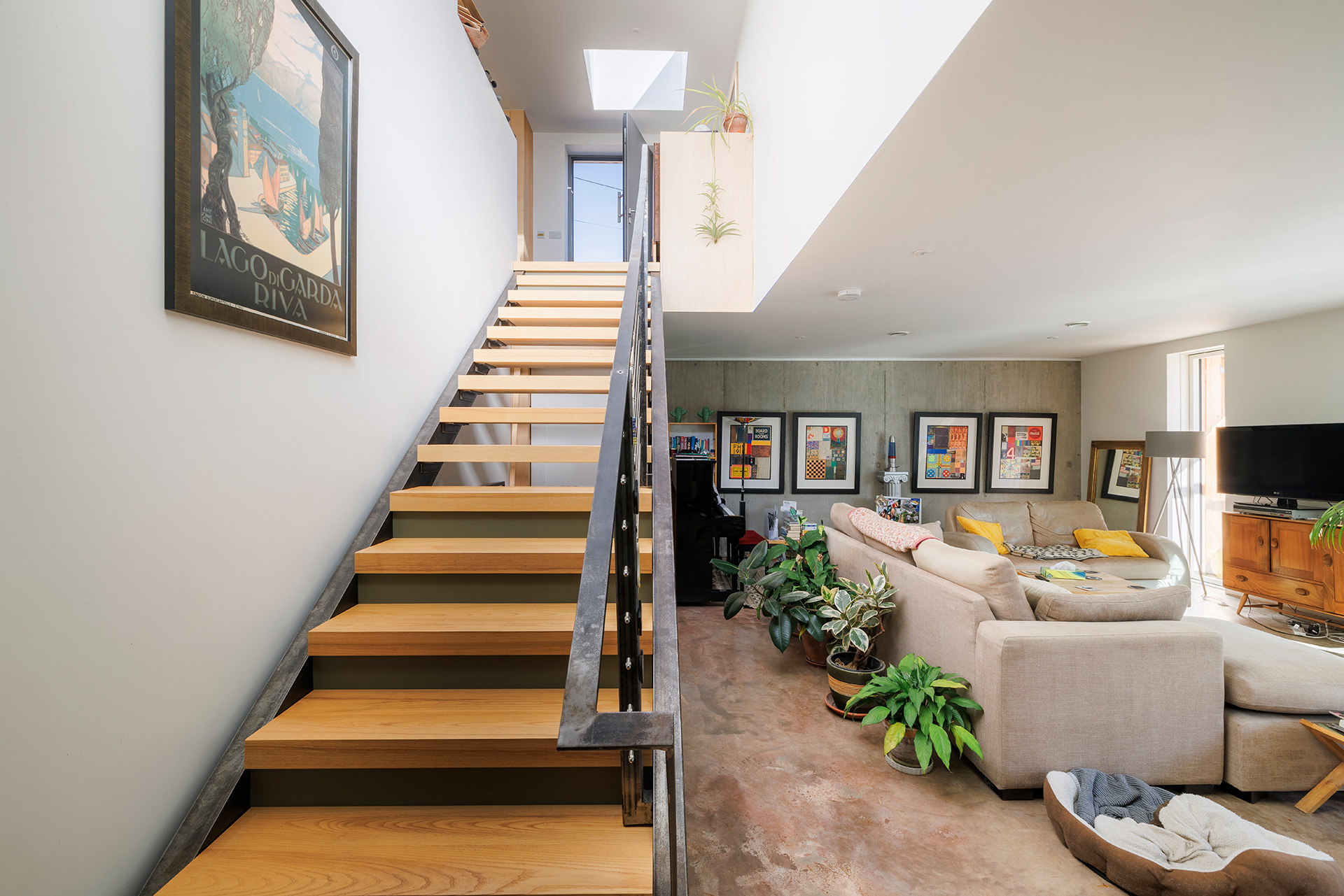 open tread staircase in open plan living space with concrete walls