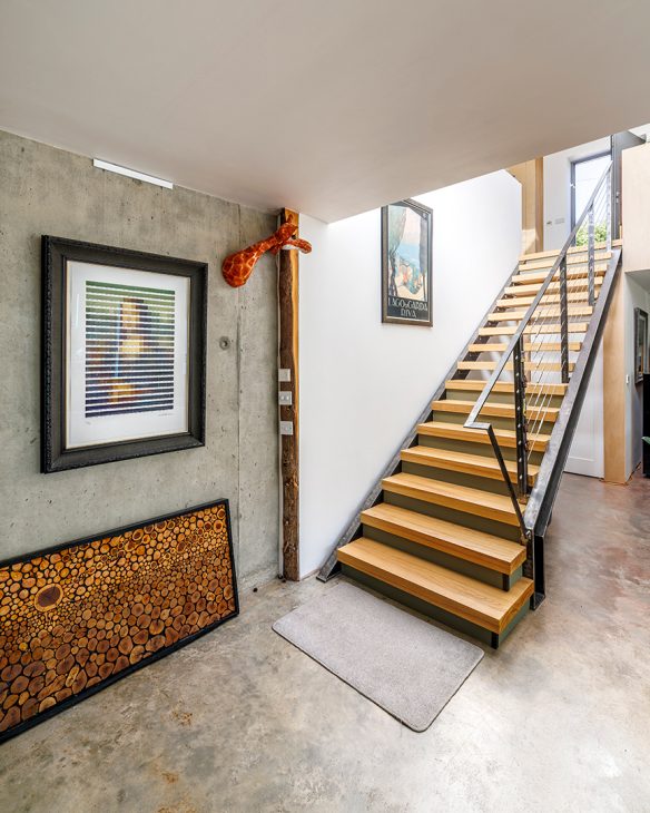 open tread staircase in open plan living space with concrete walls
