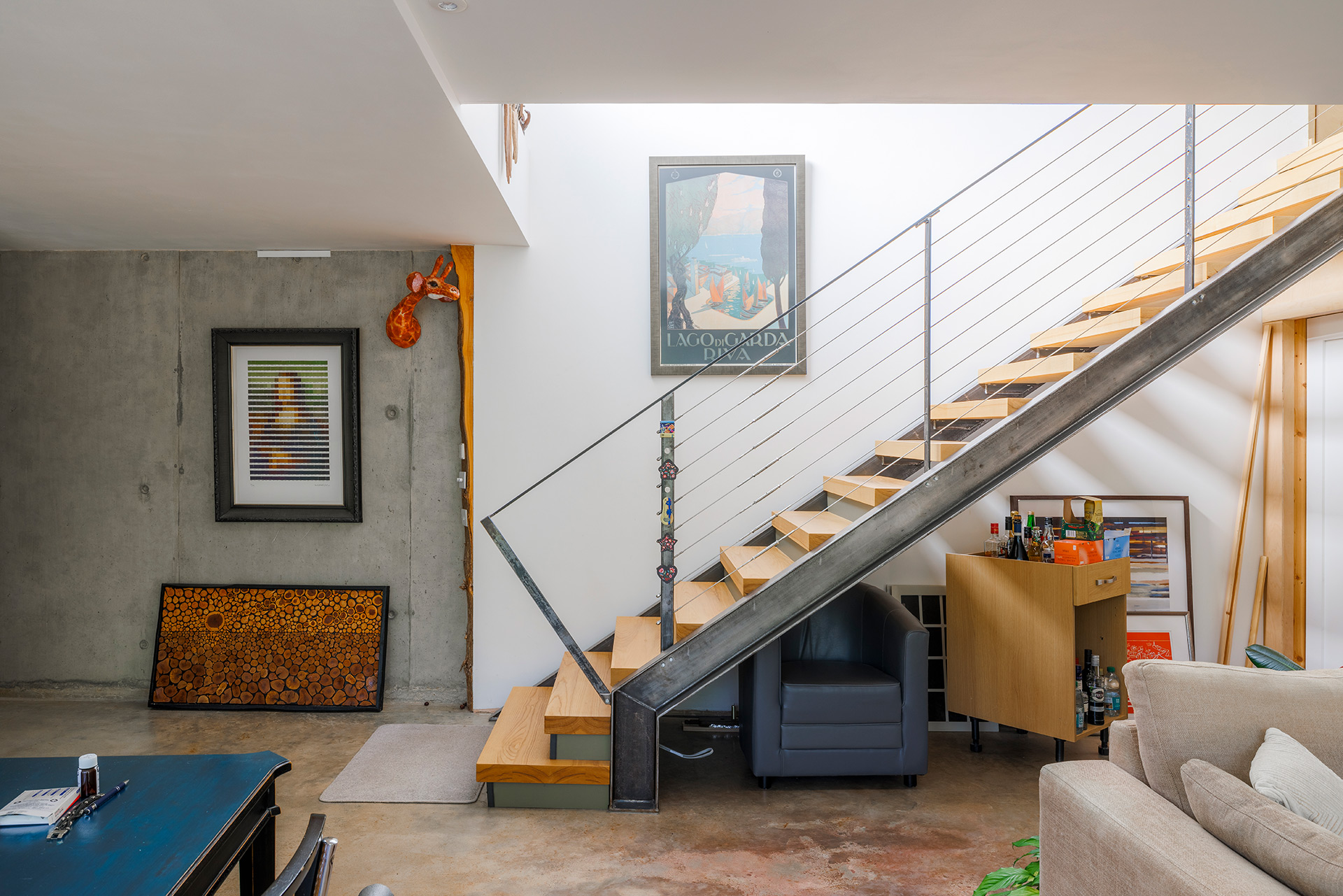 wooden open-tread staircase with metal ballustrade and concrete walls