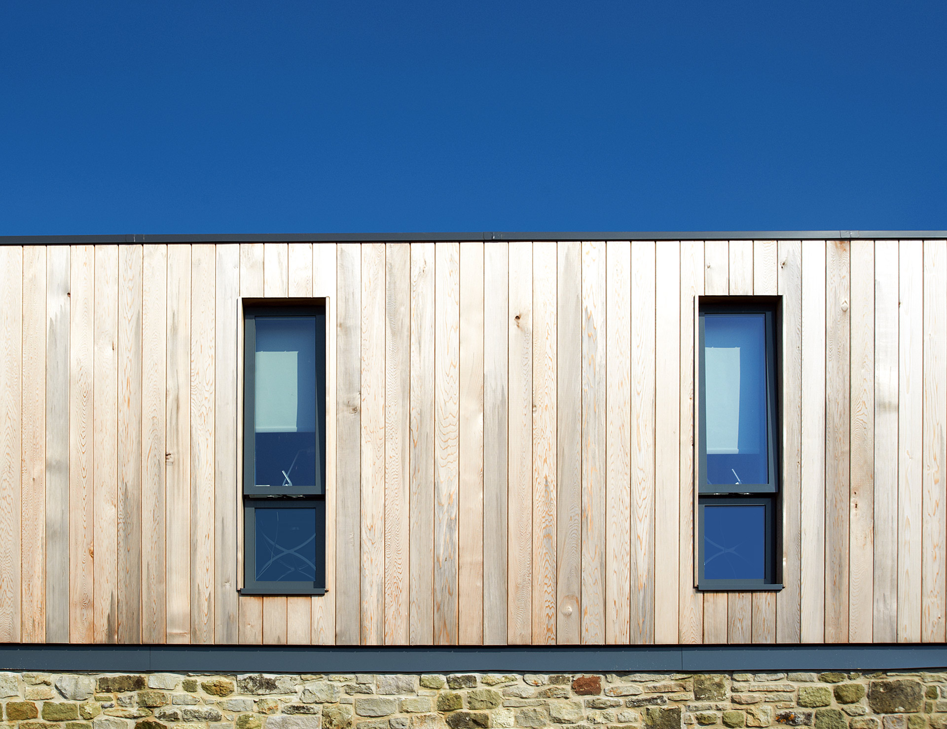 detail of timber cladding on first floor with windows