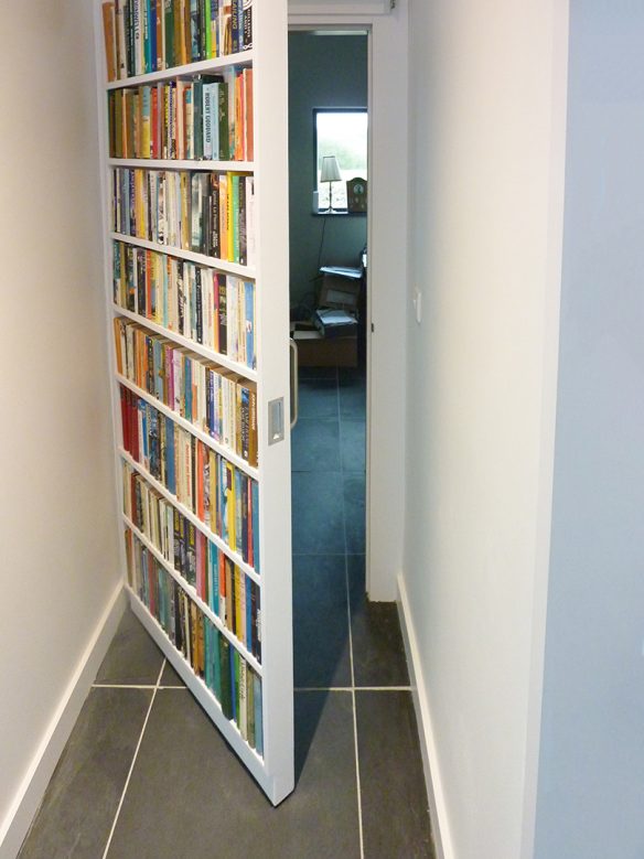 hidden door in hallway with book design on front
