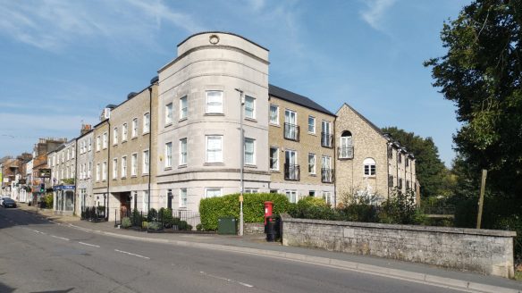 corner building with white curved wall next to bridge over river