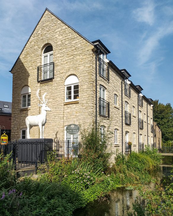 converted flats on riverside with white stag statue outside