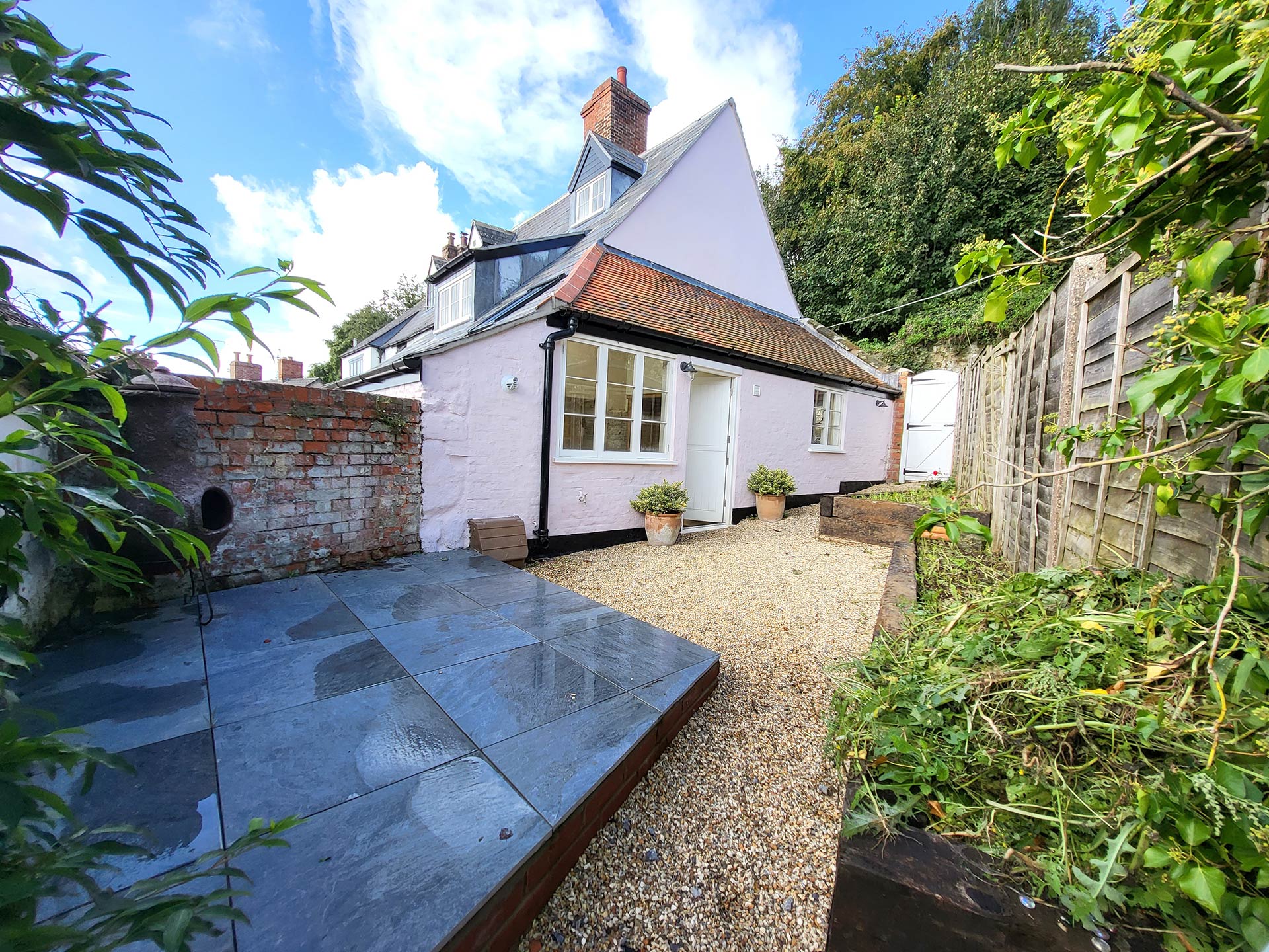 rear view of pink cottage with enclosed courtyard garden