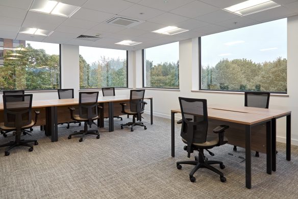 internal office space with tables and chairs and large windows