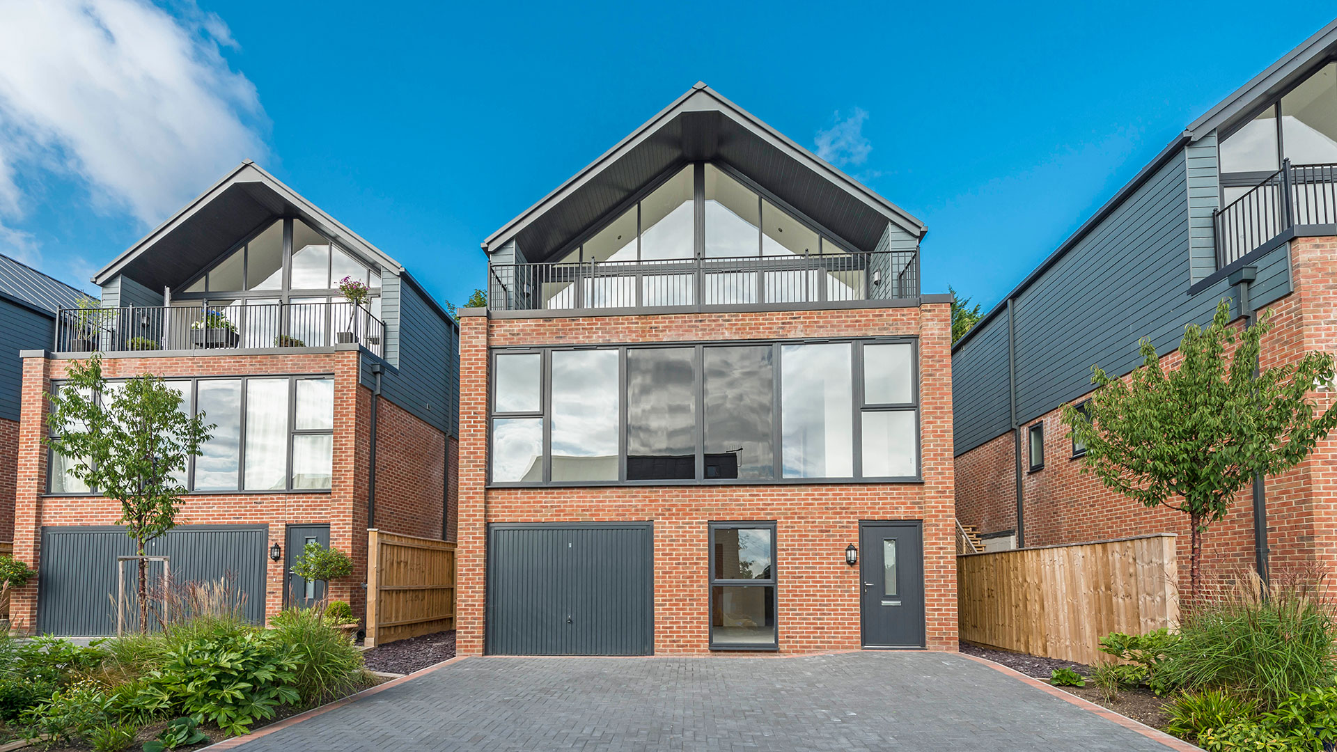 front view of contemporary red brick house with large windows and balcony