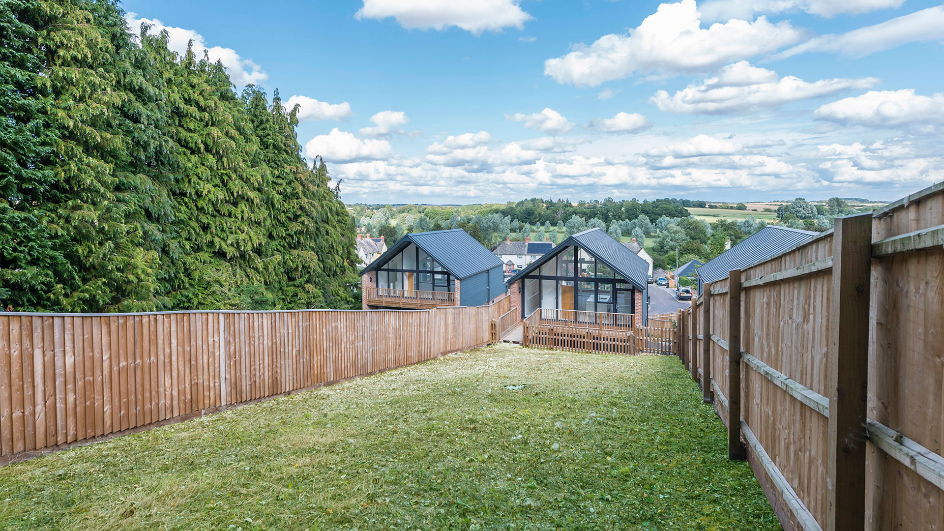 view of house from rear of sloped lawn garden