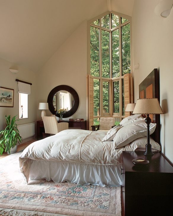 double height bedroom with feature window looking out to trees