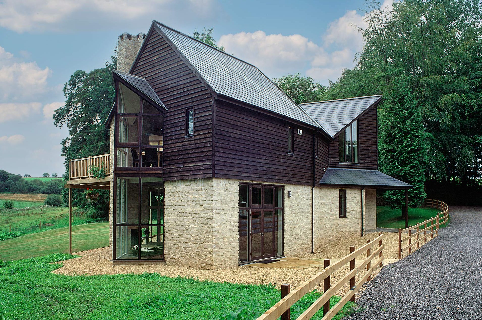 approach view of stone and wood clad house